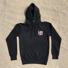 Load image into Gallery viewer, HB Huntington Beach, California Premium Pullover Hoody Black Fleece  White and Orange HB Print, Front and Back 8.5 oz., 3 end fleece, 100% cotton face exterior, 65% cotton 35% polyester blend. Unisex, ultra soft, side seamed, tightly knit, 3 end cotton faced, 3 panel hood, flat draw cords, 2 needle cover stitching at cuffs and waistband, single needle edge stitch at collar, silver gromm.