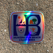 Load image into Gallery viewer, HB Huntington Beach, California, classic HB City logo metallic hologram, high quality, vinyl sticker. Great for outdoor or indoor use! This classic HB logo has the sail boats and sun in the upper left corner representing Huntington Harbour sailing, the house and tree in the upper right corner representing family life, the atom in the bottom left corner representing the ingenuity of our aerospace industry and a surfer in the lower right corner representing our surf culture here in Huntington Beach.